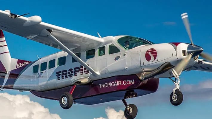 A Tropic Air plane in flight above the clouds